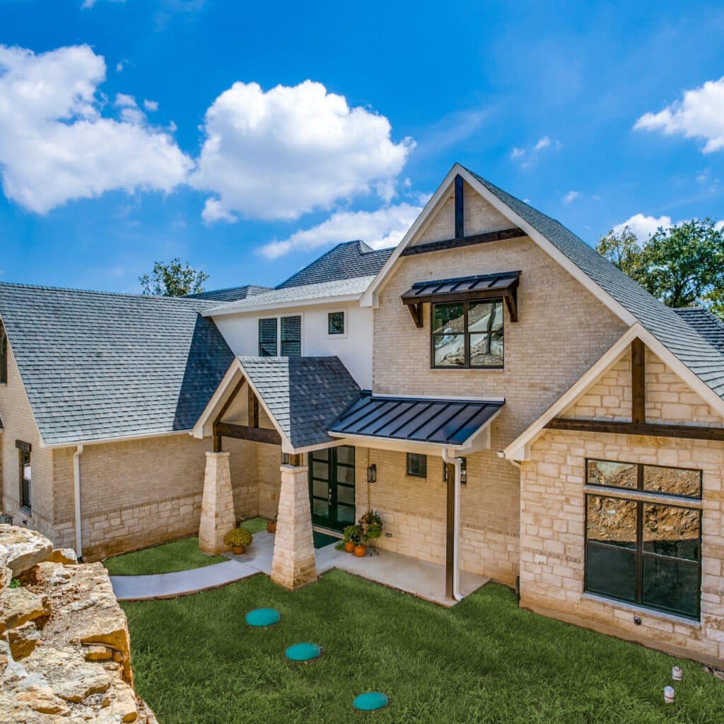 Stone and brick custom home with timber gable accents by Edge Crew