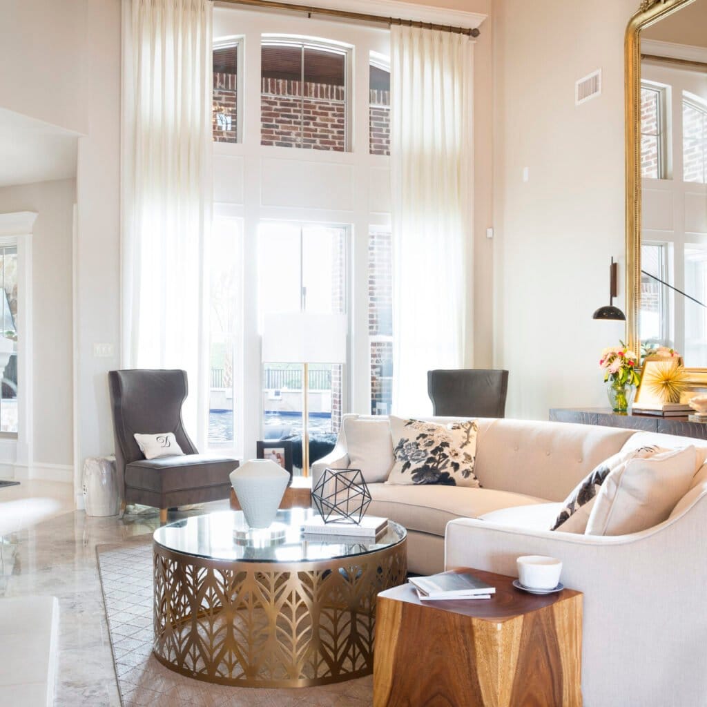 Light-filled living room with tall windows, a curved sofa and fireplace